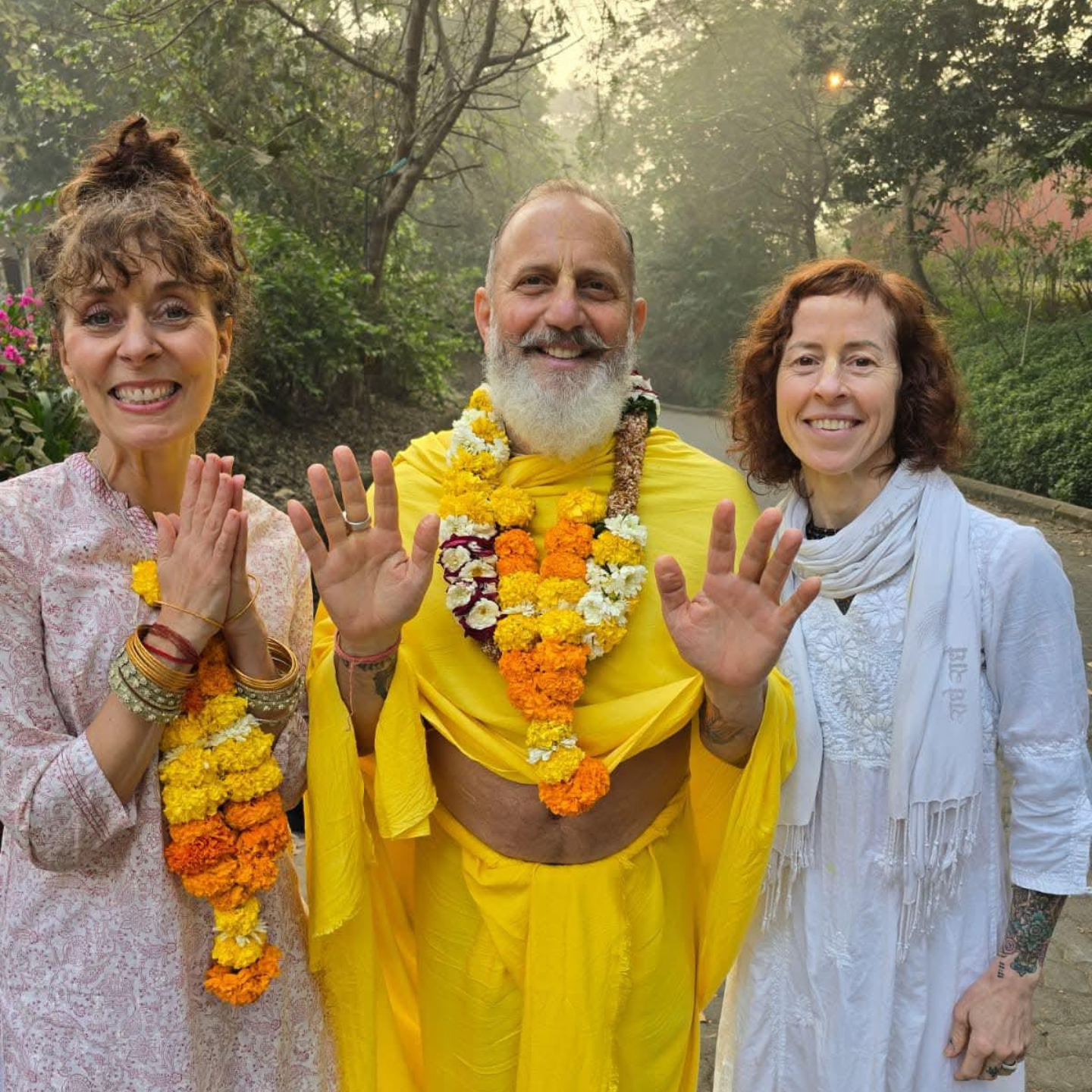 Raghunath Cappo, Cindy Lunsford, and Bobbie Marchand wearing flower garlands at Govardhan Ecovillage in India.