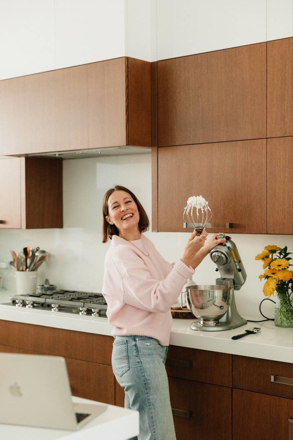 Arianne Jones laughing in her kitchen beside a stand mixer