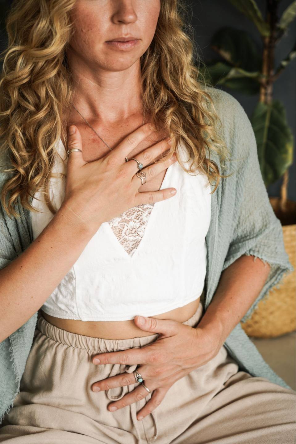 Woman resting one hand on her chest and one on her belly during a breathwork practice