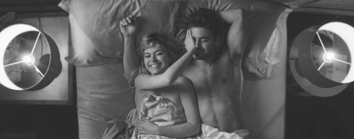 Couple being playful and silly and romantic in bed GIF