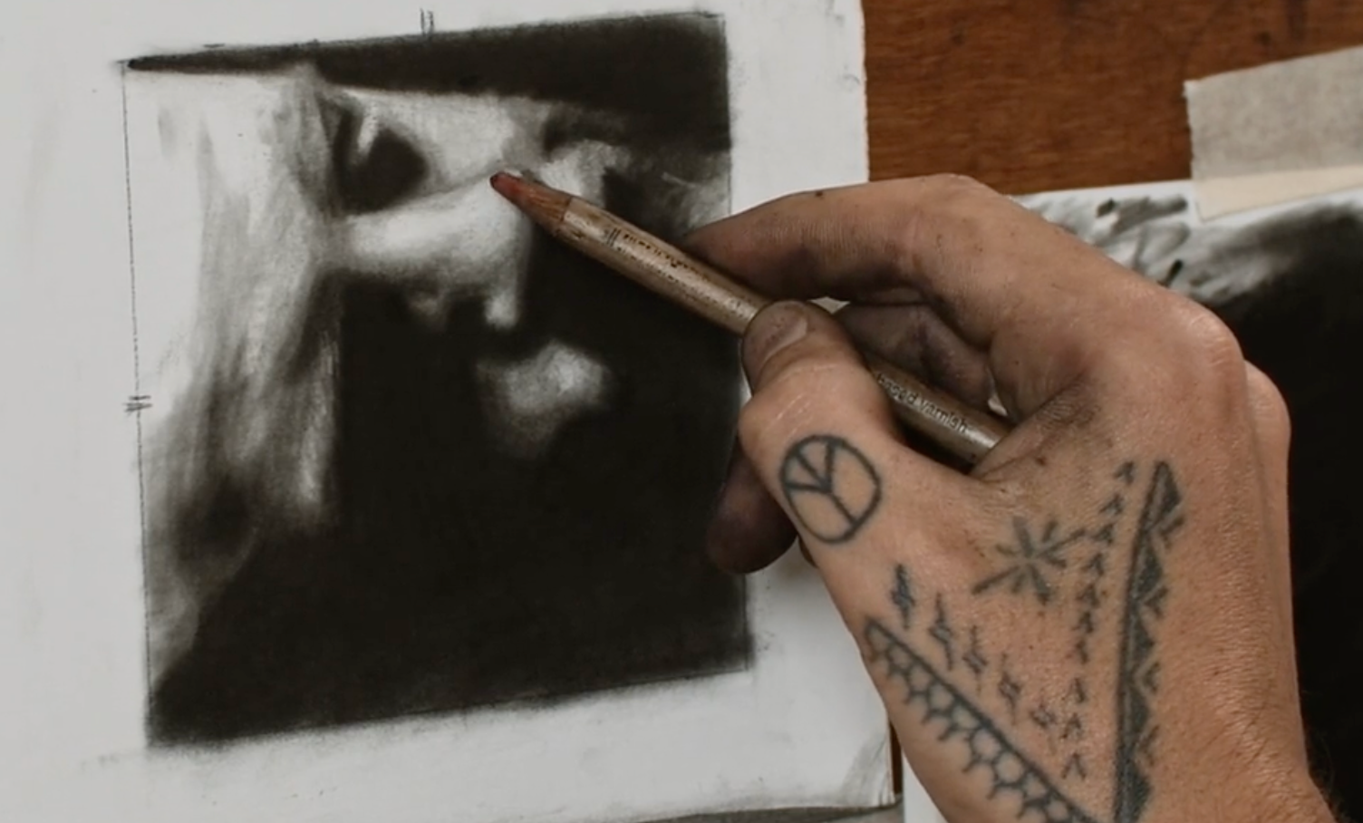 Artist drawing a charcoal portrait step by step