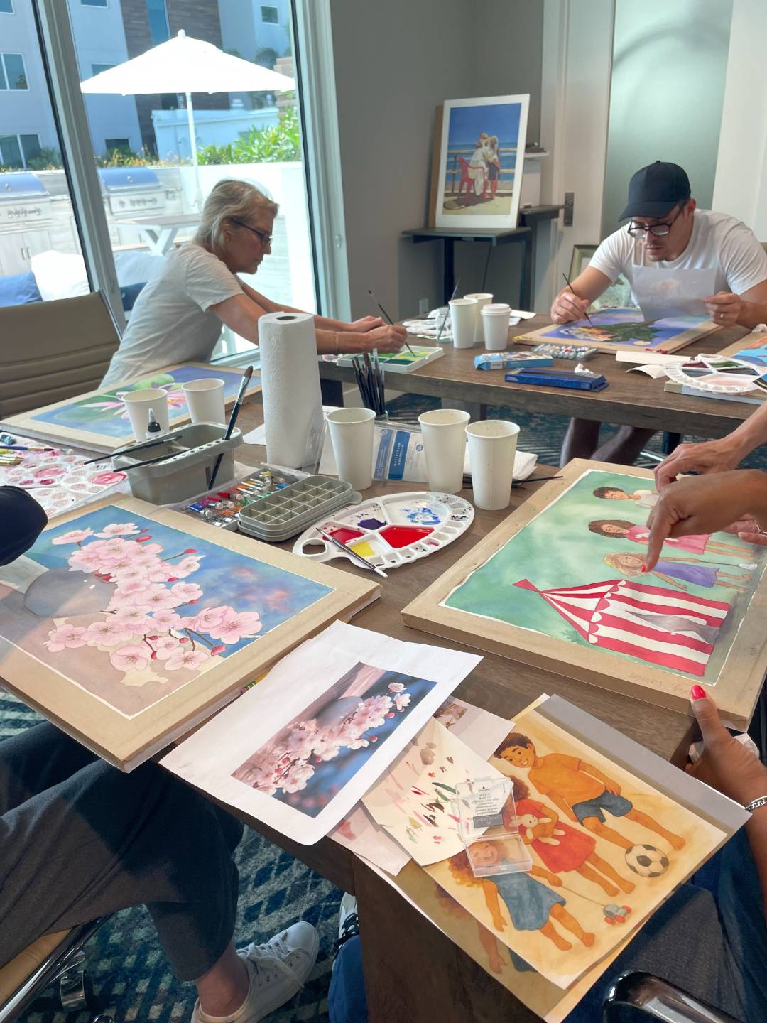 Artists holding the watercolors they finished with Pomm