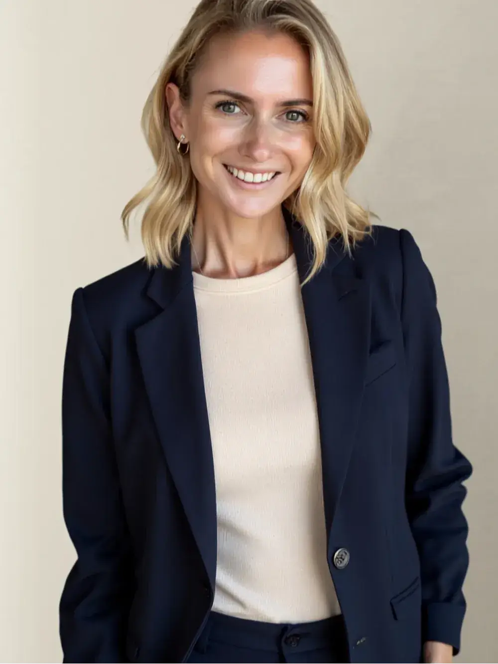 Coach Amanda Doyle smiling to the camera, wearing a dark blue coat and white shirt
