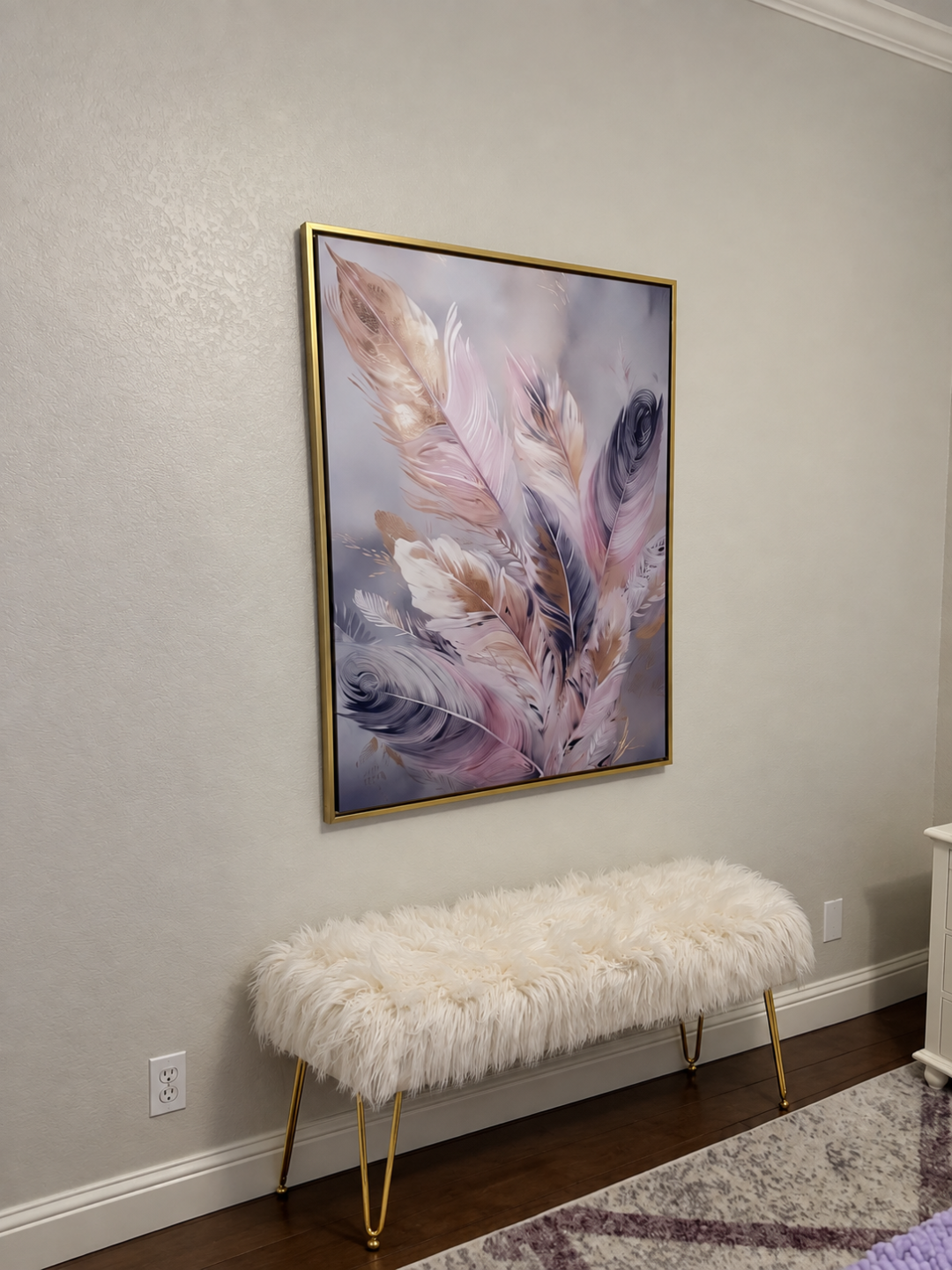Feather painting in a gold frame above a white fur bench in the Haniel room