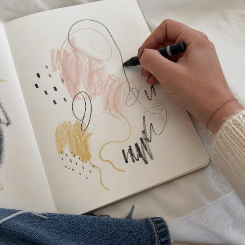 close-up of a woman drawing in a journal