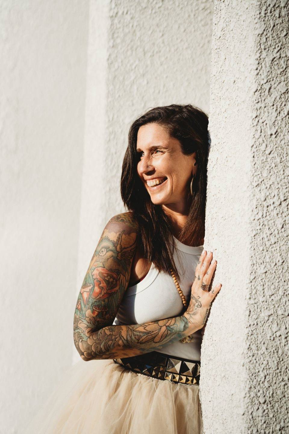 Isabelle Houle, souriante, appuyée contre un mur blanc