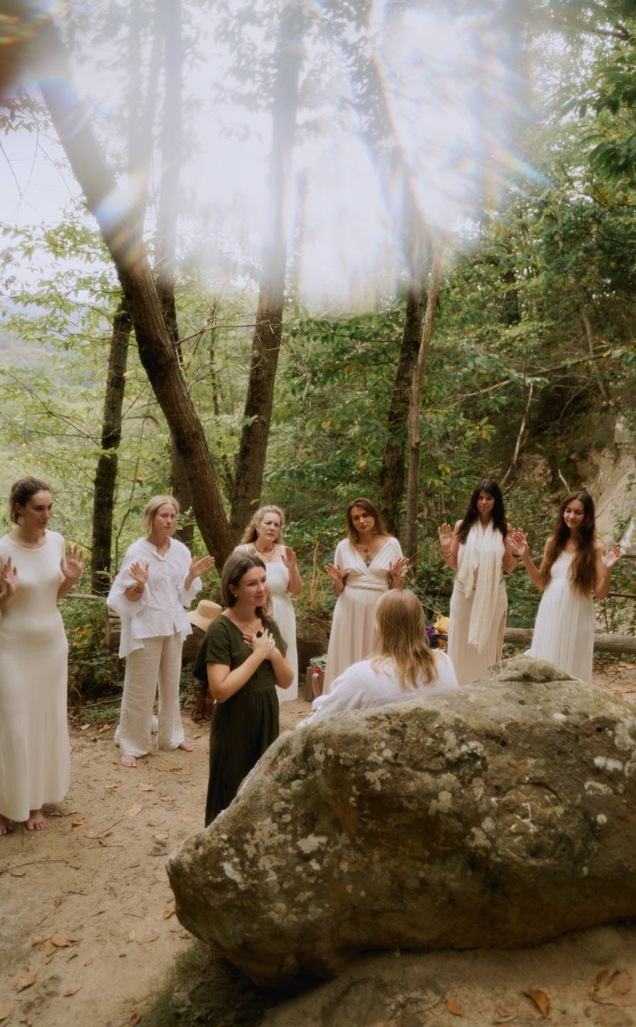 Women gathering for ritual among trees and ancient stone during Natalia’s retreat in Southern France