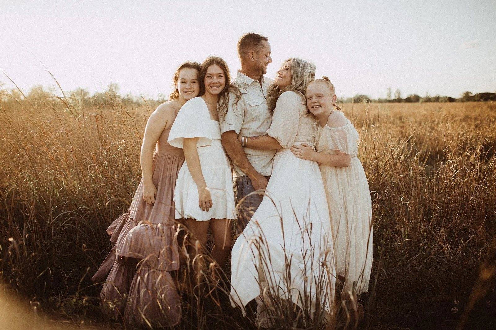 An extended family gathered close in a golden field