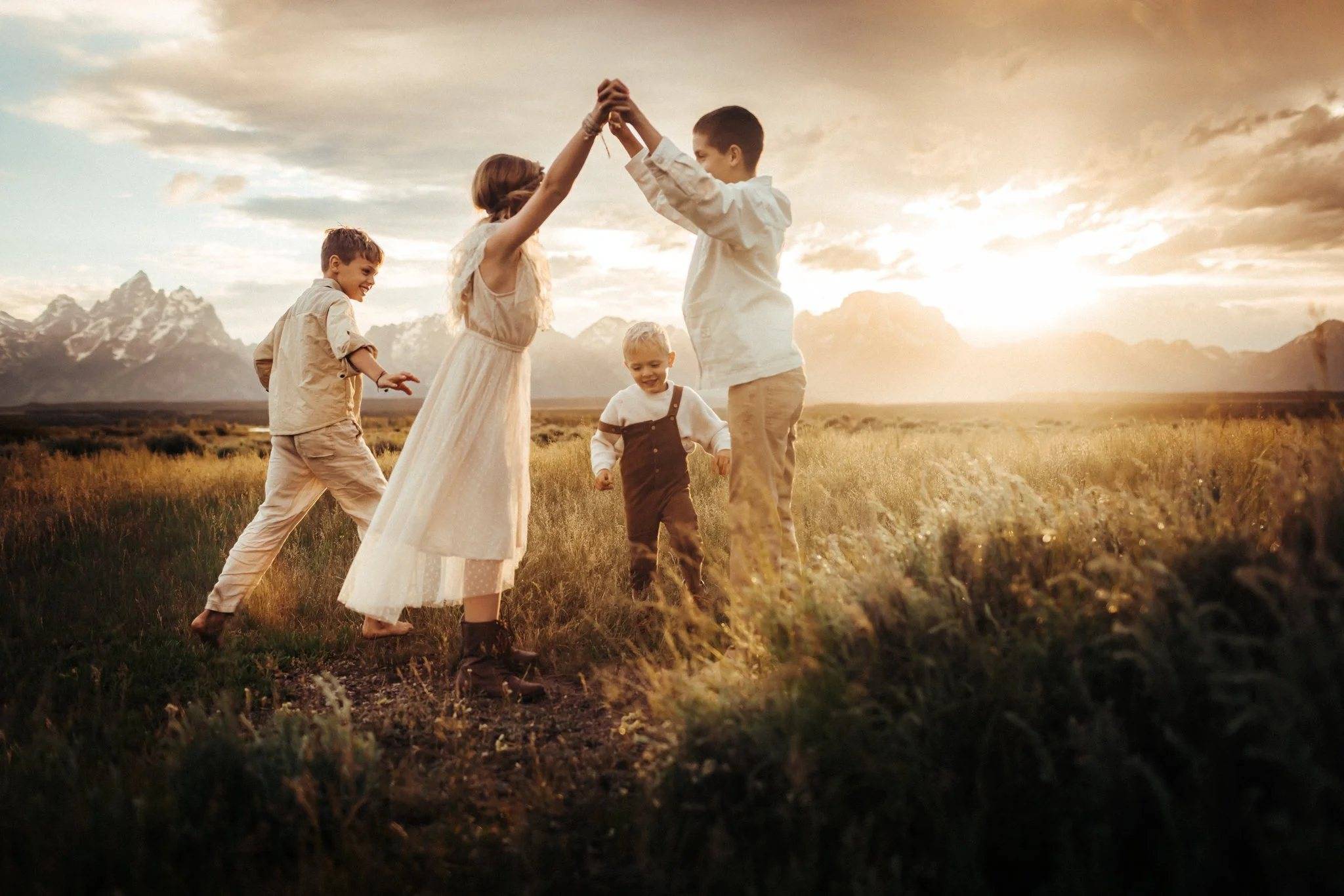 A family dancing together in a golden-hour meadow, photographed by Nina Turek