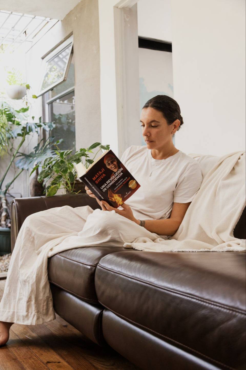 Una lectora descansa en un sofá con el libro