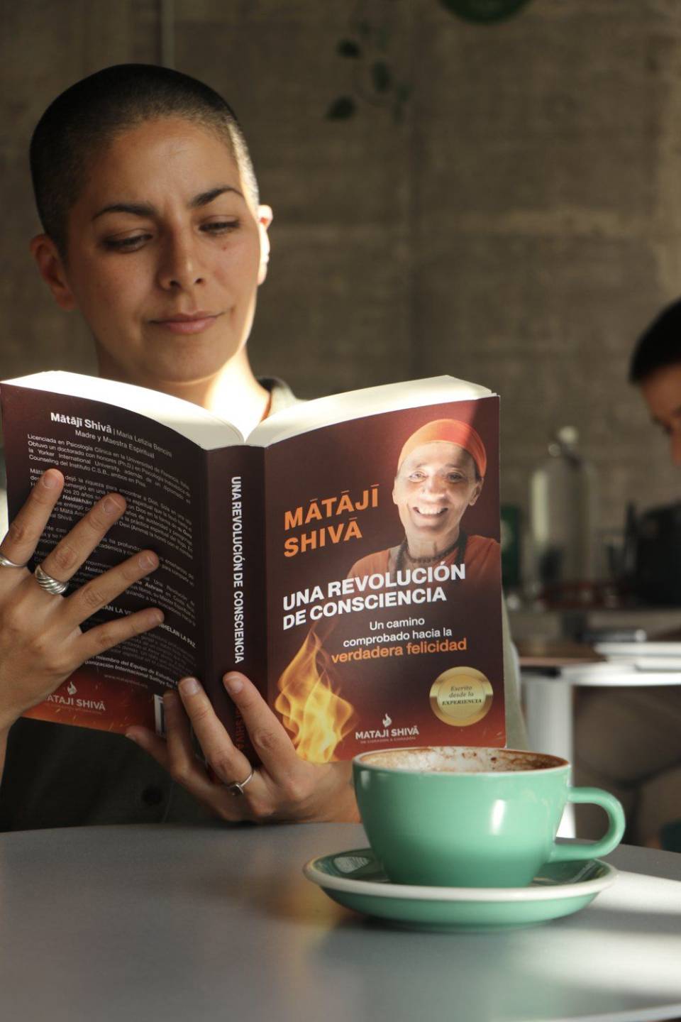 Una mujer lee el libro con una taza de café