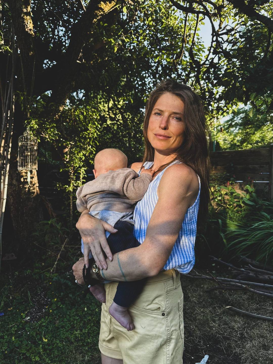 Yolande Norris-Clark, founder of The Source, holding her baby in the garden