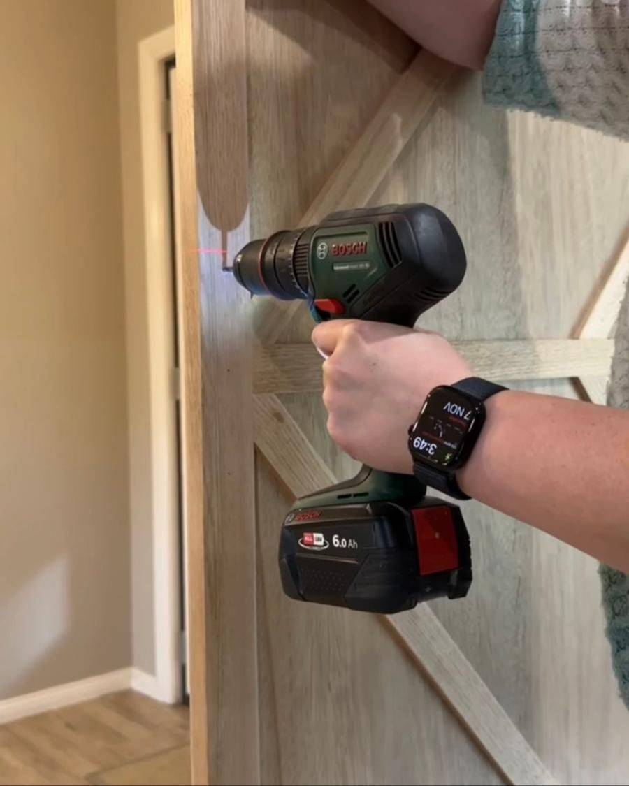 Drilling into a timber barn door she built
