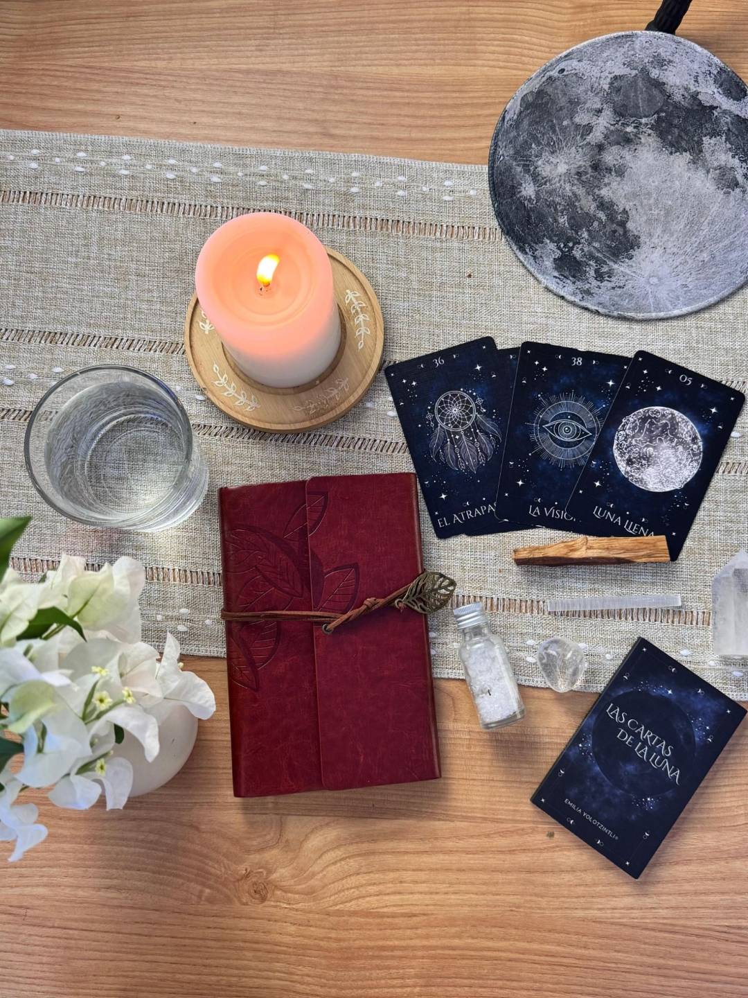 Cartas del Oráculo de la Luna con una vela y una libreta de práctica