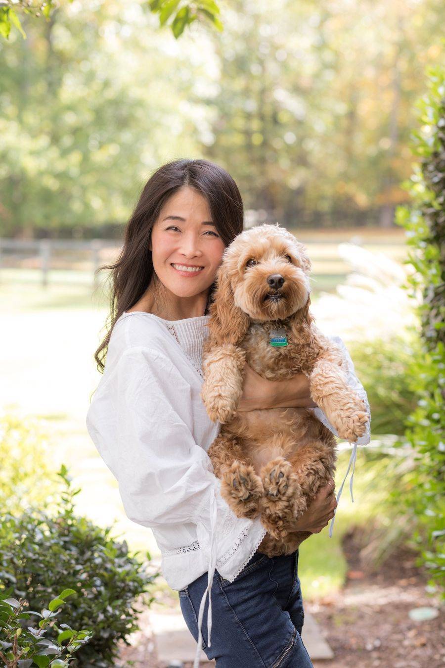 Dr. Connie Cheung outdoors holding her dog