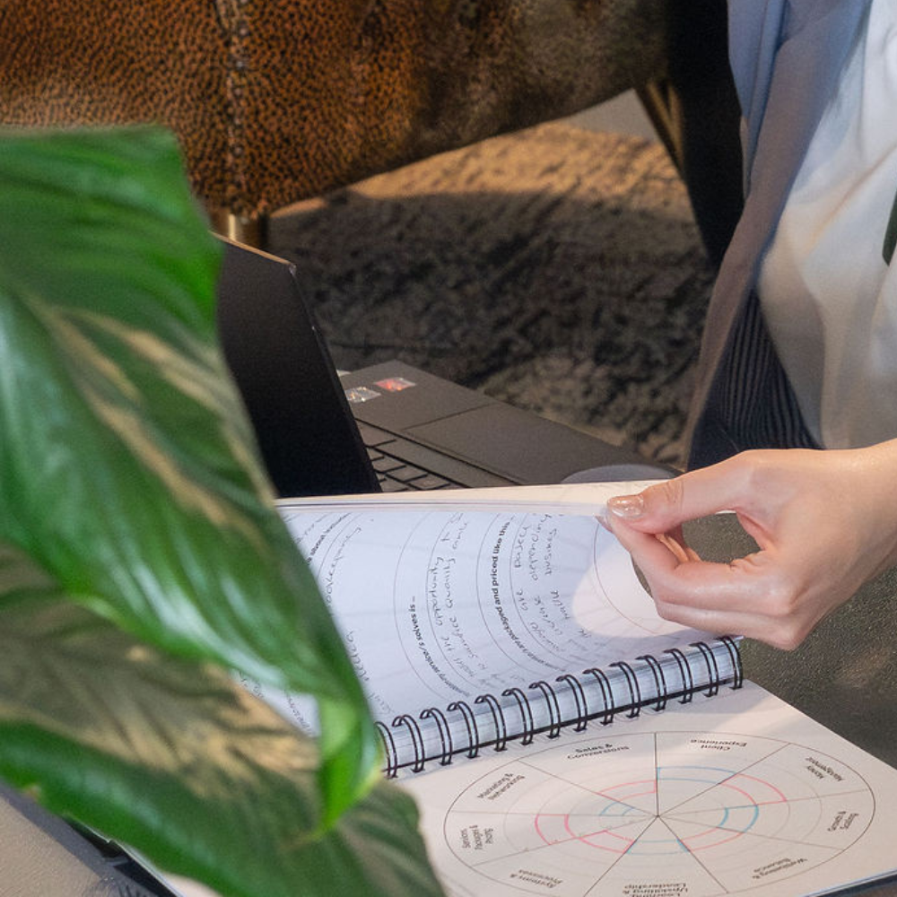 Marianne flicking through filled out VA Business Planner pages
