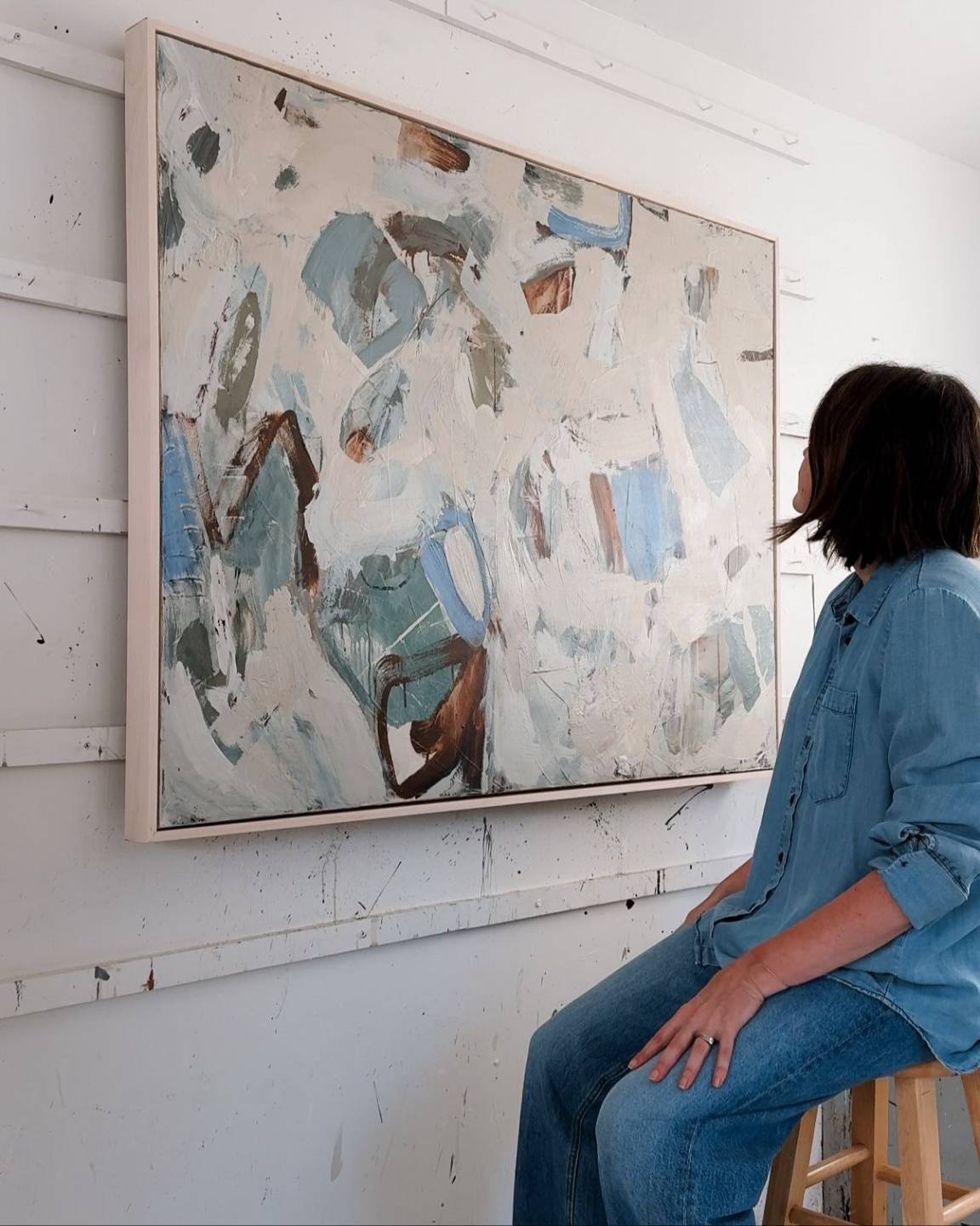 Jennifer Daily looking at her painting in the studio