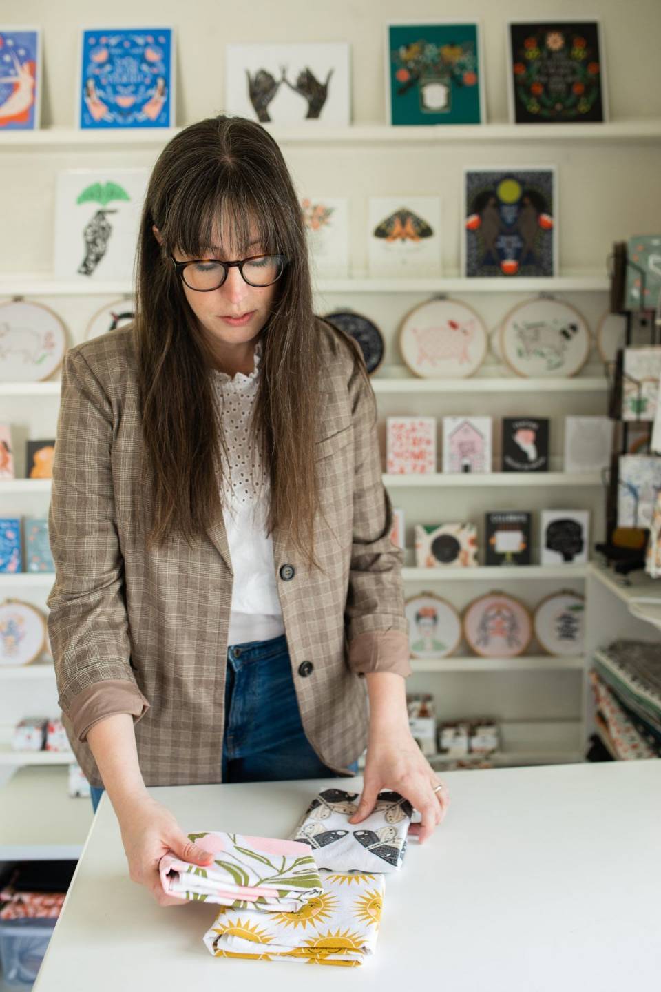 Stacie Bloomfield folding Gingiber tea towels in the studio