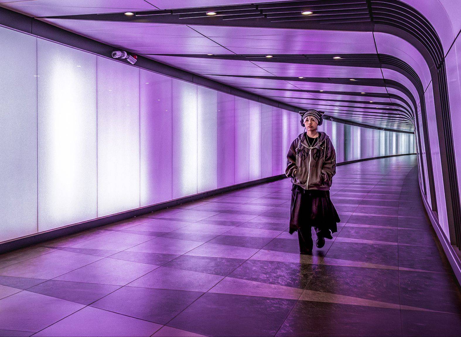 Person walking through the purple-lit King’s Cross tunnel, London, street photography by Mark Kaye