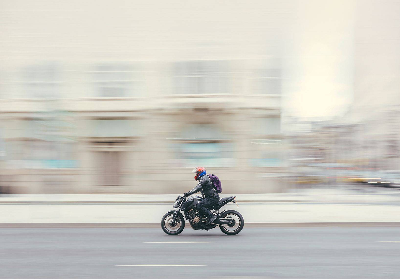 Motorcyclist panned with motion blur on a city street, street photography by Mark Kaye