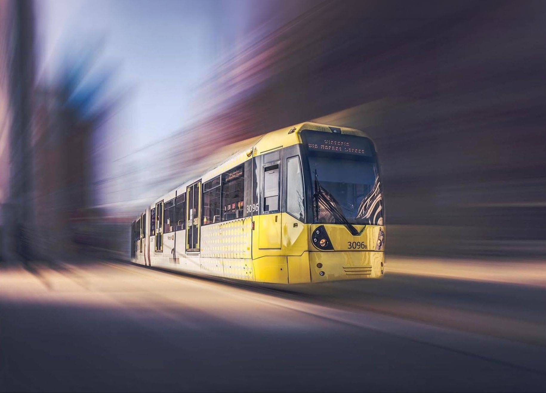 Yellow Manchester Metrolink tram with motion blur, street photography by Mark Kaye