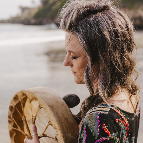 Allison Lorne holding a frame drum in golden light