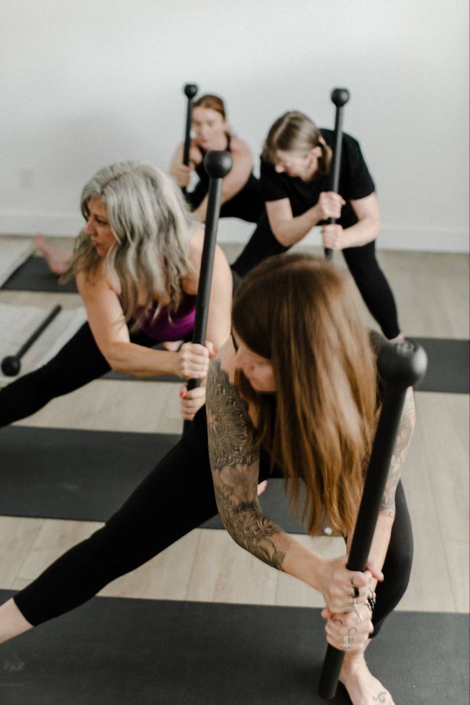Women training with steel maces in a group class