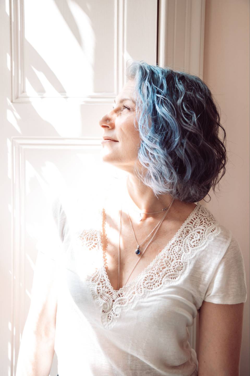Katie Crooks with eyes closed in soft window light