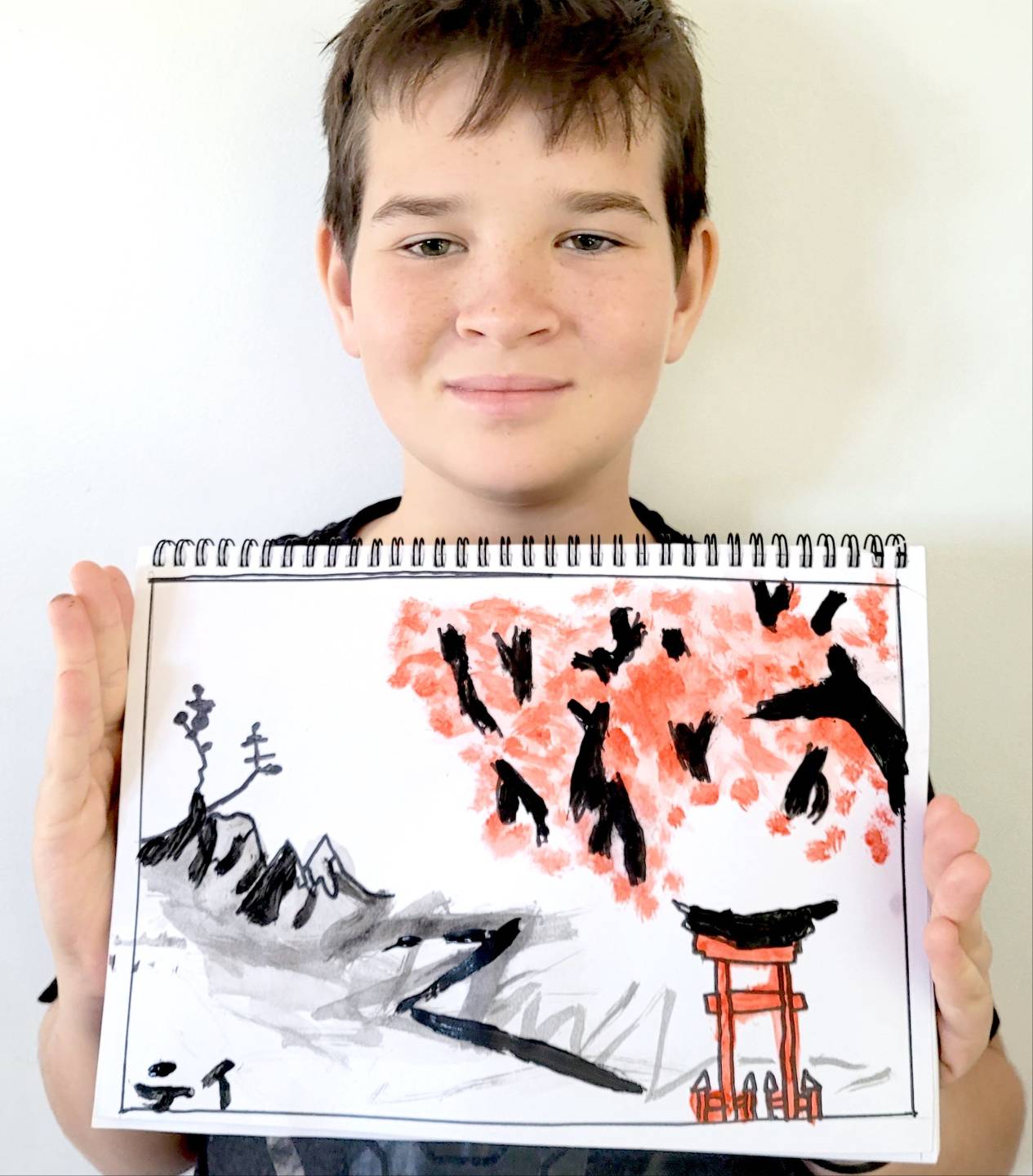 Ti, age 12, holding his Artventure artwork of a Japanese garden