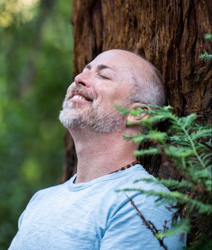 Man laughing with hands together in prayer position