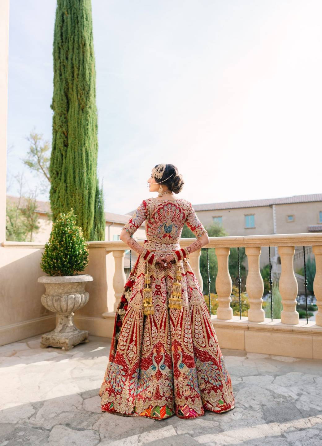 Bride in a red embroidered lehenga on a terrace - Happy Soul Films