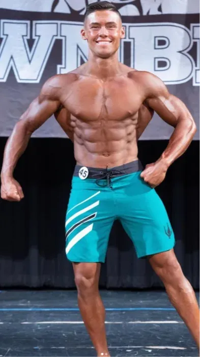 andre dcruz mens physique bodybuilder stage shot