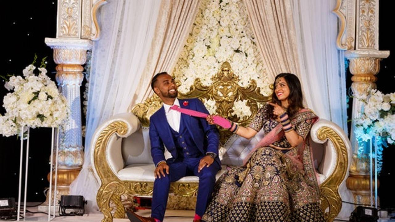 Bride and groom laughing together on a floral reception stage, filmed by Happy Soul Films in the GTA