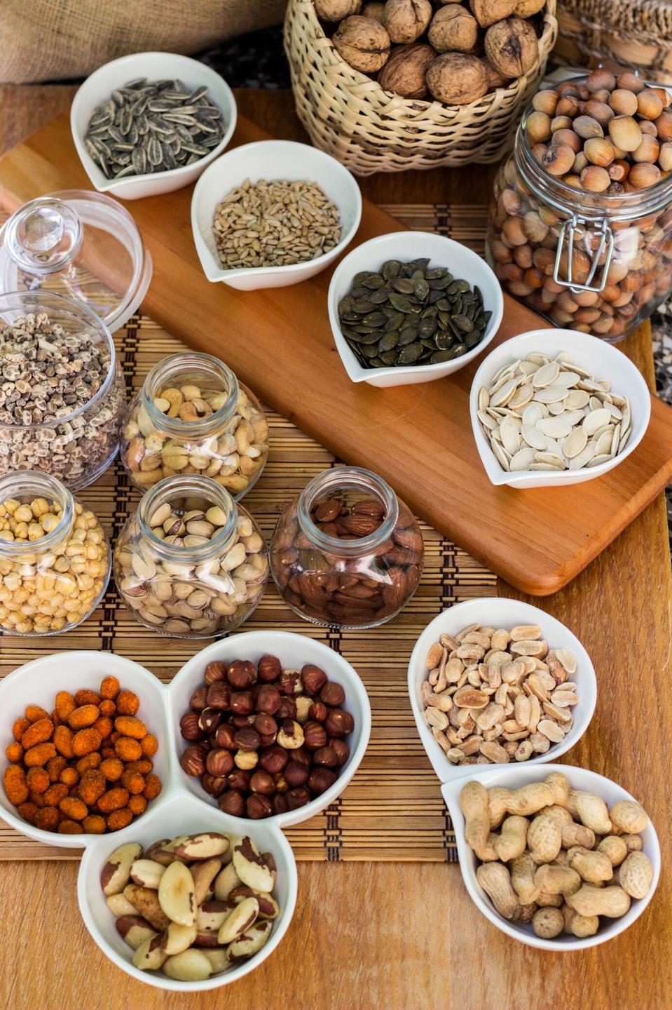 omega 3 sources, bowls of sunflower seeds, pumpkin seeds, hazelnuts, walnuts, pistachios, almonds and peanuts