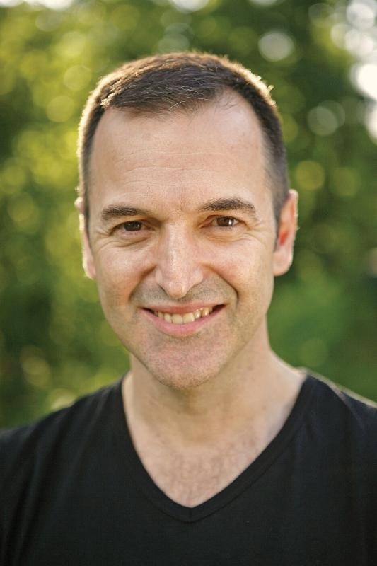 Anastasi Siotas smiling in front of a natural green background