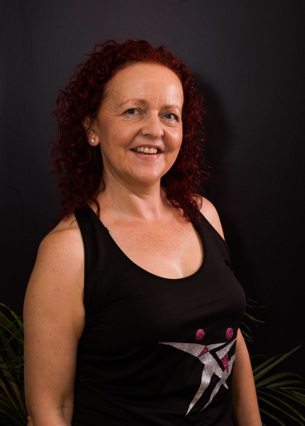 A smiling photo portrait of Claire Waite Brown in front of a dark background