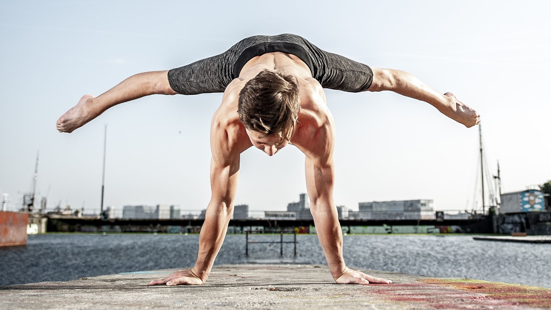 Man balancing on his hands while stretching his legs outwards in the air