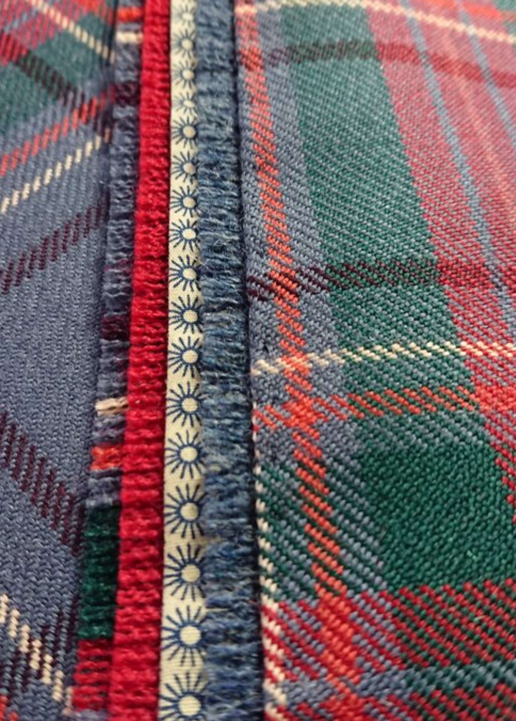 A close up of a blue, green, red and orange kilt, showcasing the lining