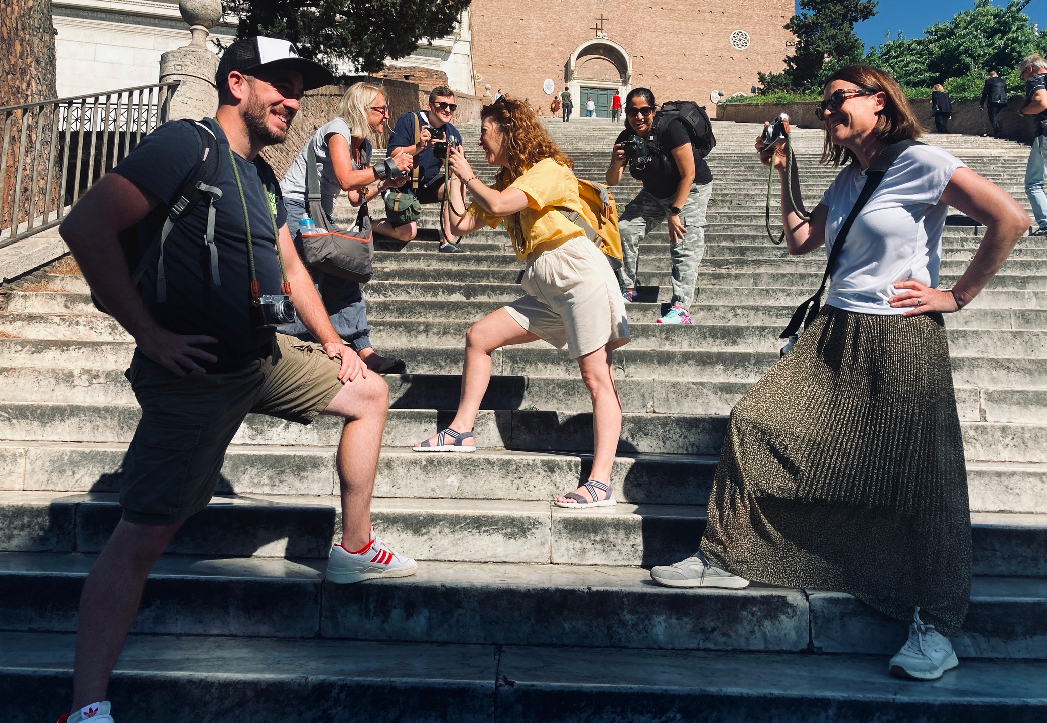 group of six photographers posing for fun with cameras on steps