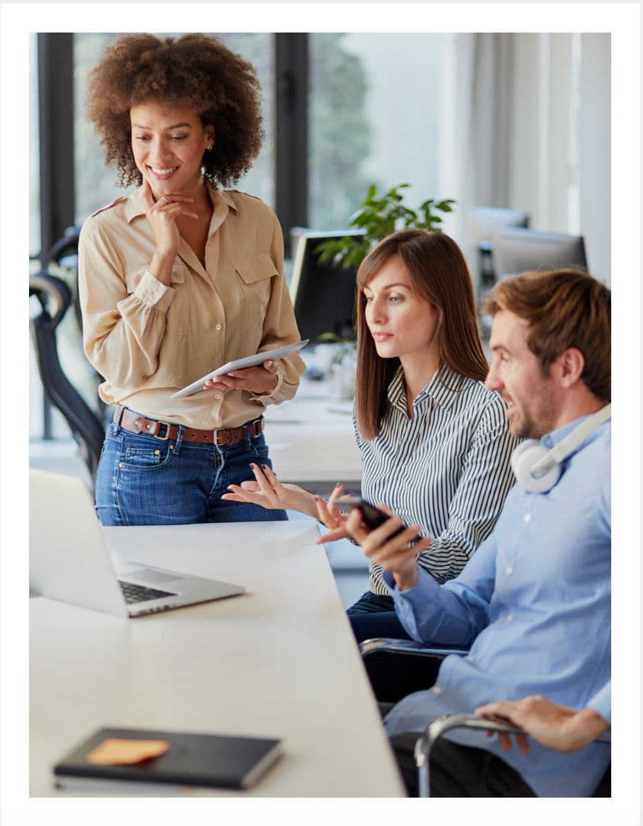 Three colleagues meet around a laptop