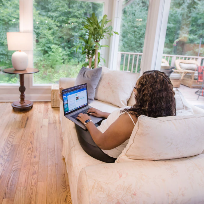 Rachel Gainsbrugh working with a laptop on  a couch