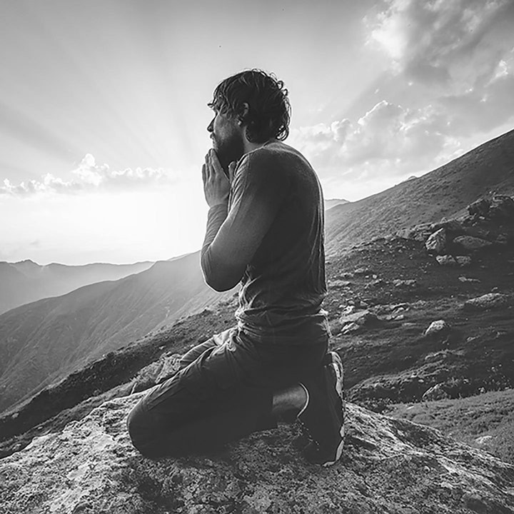 man practicing Tantric meditation on a mountain top