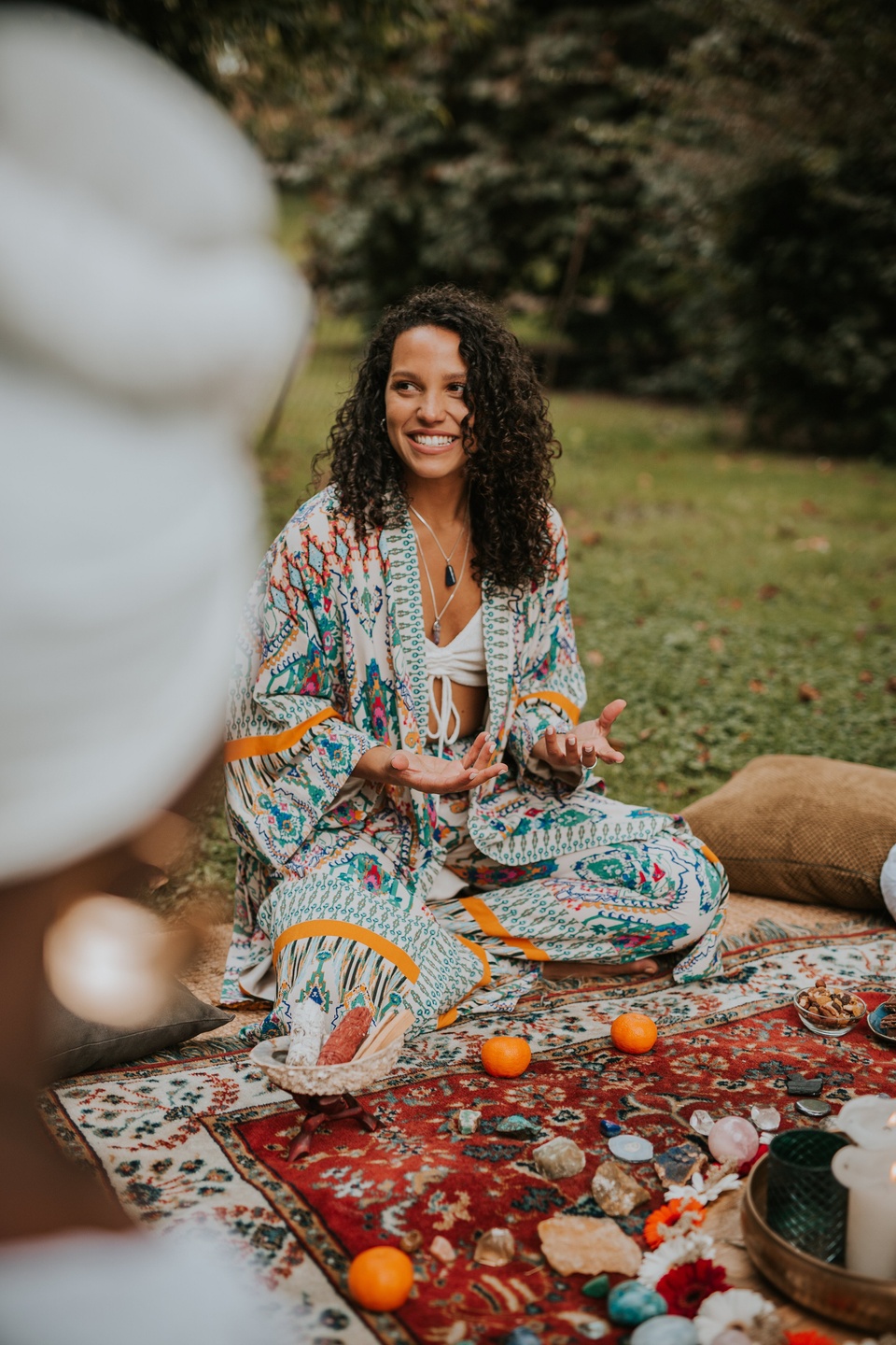 spiritual woman speaking at a woman circle outside in nature with an altar
