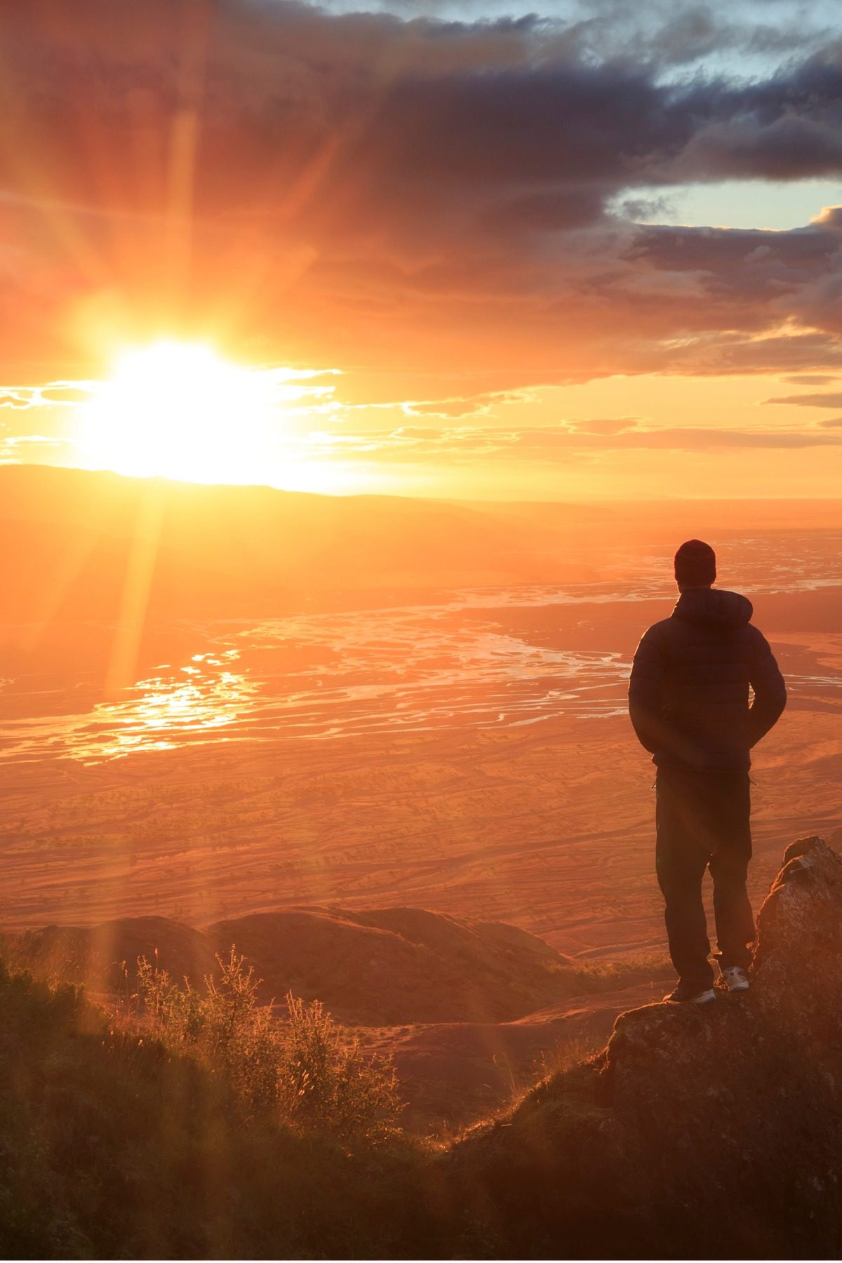Person watching sunset over valley