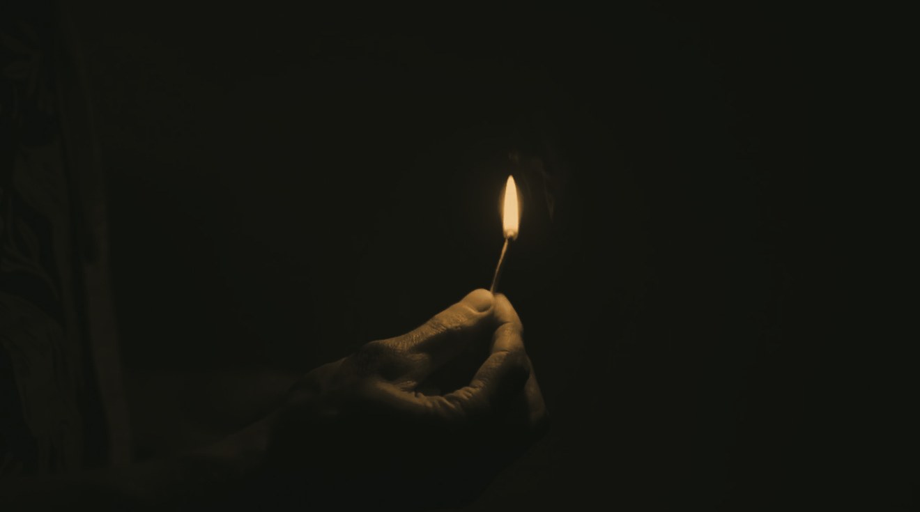 A small flame held in the darkness