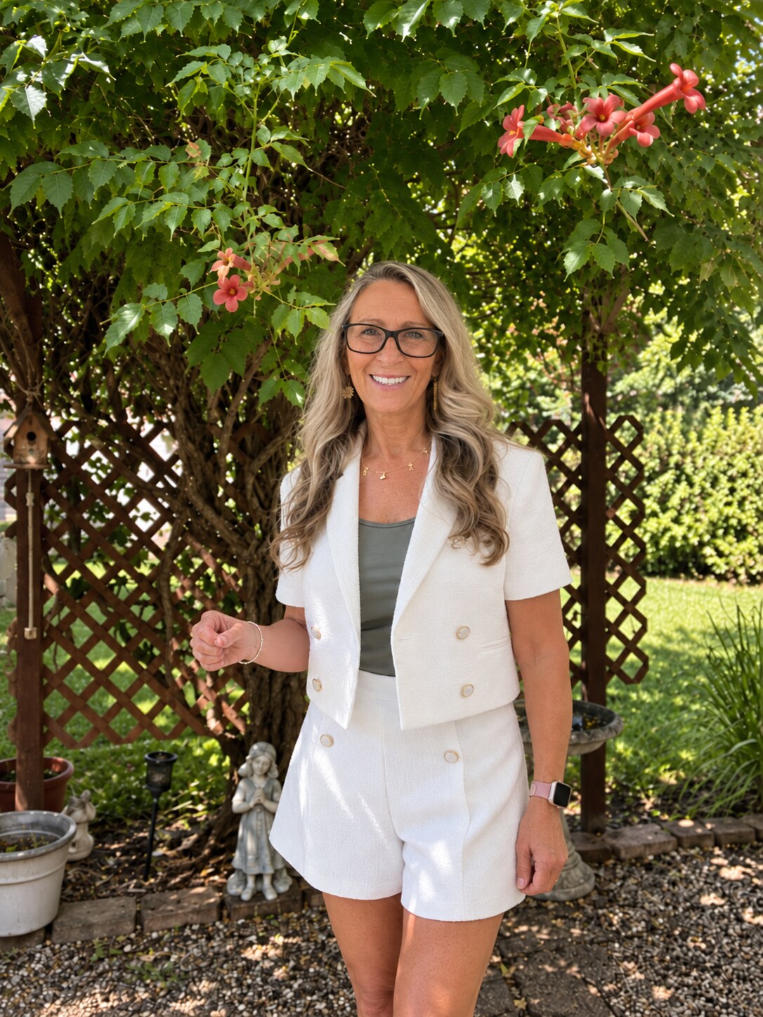 Jackie L Armstrong standing beneath flowering greenery