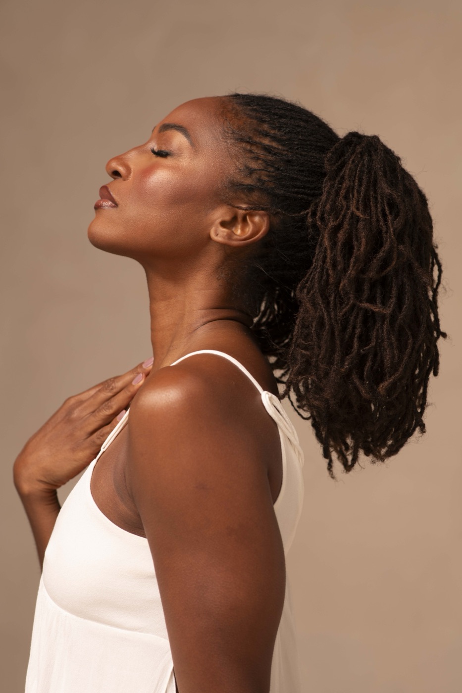 Koya Webb with her eyes closed and her hand resting on her chest