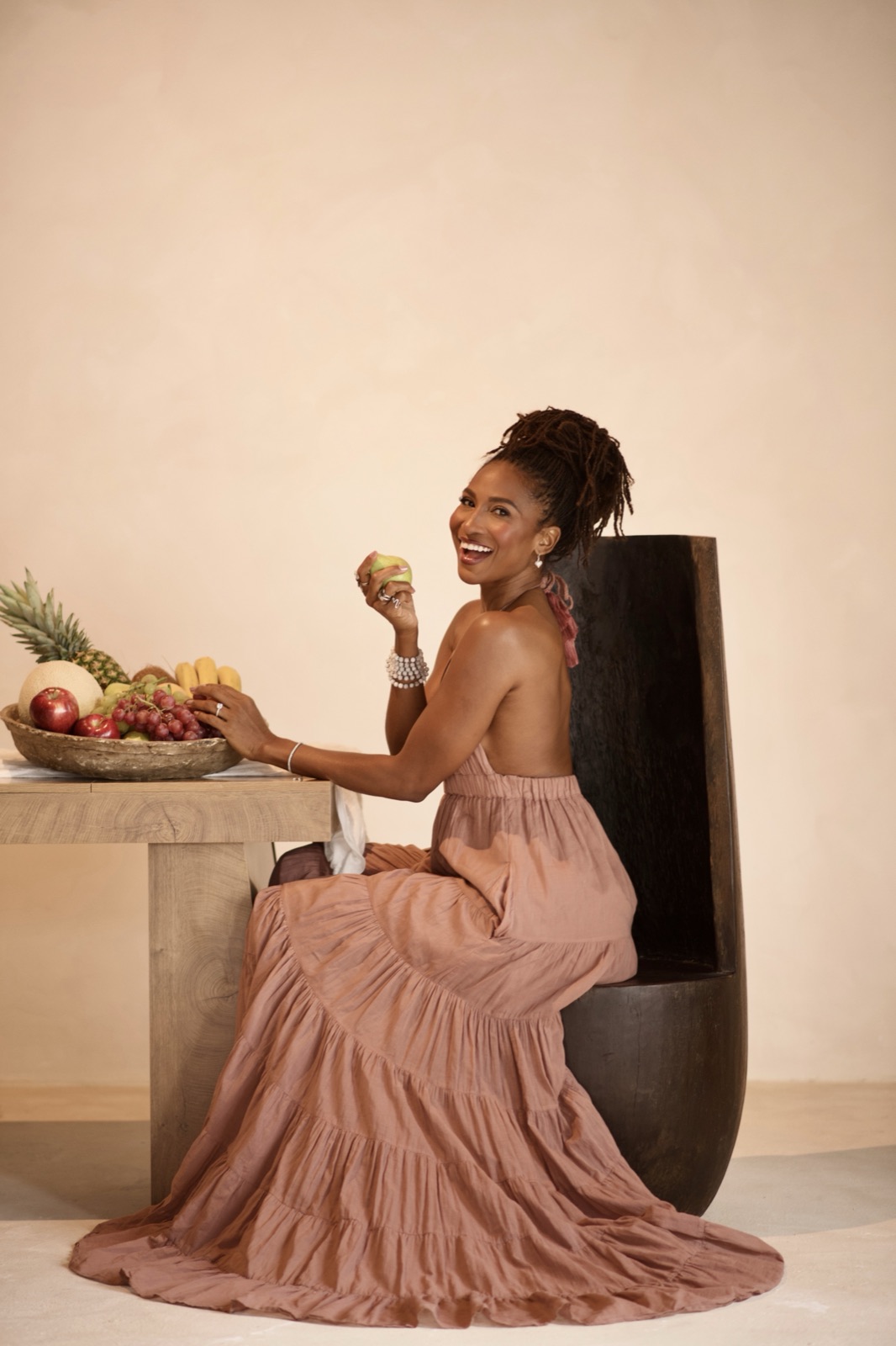 Koya Webb smiling at a table of fresh fruit