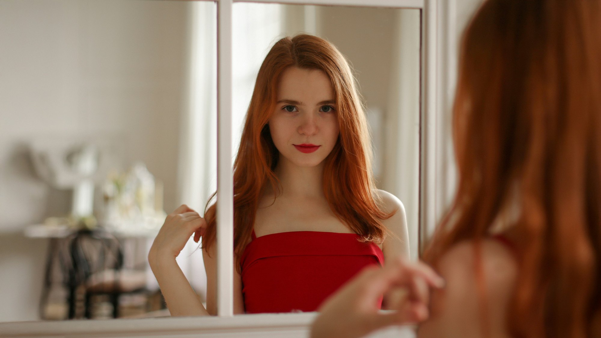 Una mujer se mira a los ojos frente a un espejo