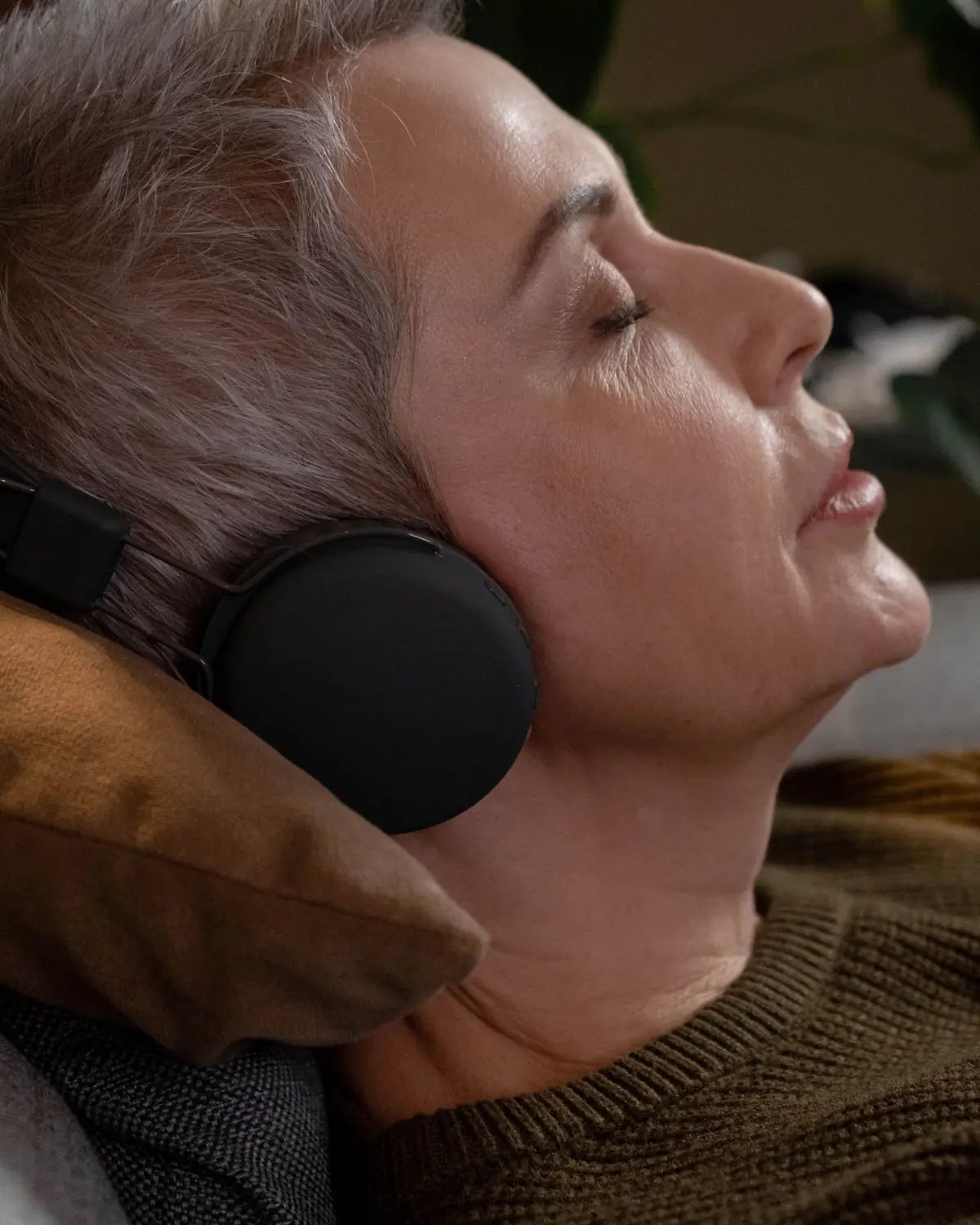 A woman relaxing with headphones, listening to Wholetones